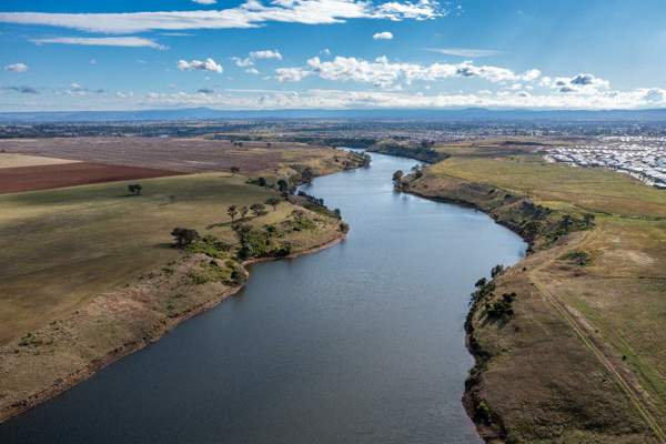 A photo of a river, paddocks and surrounding township.