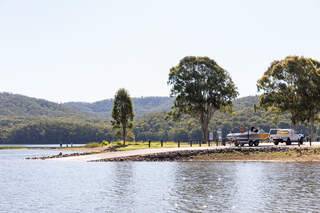 body of water with a boat and car in the background
