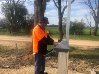 Photograph of Wayne Harris in high vis clothing and PPE working  on a piece of GMW infrastructure in the field
