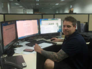 Photograph of Danni Heazlewood sitting at his management console in GMW Tatura office