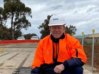 Photograph of Gary Biddle in high bis clothing and a hard hat on site