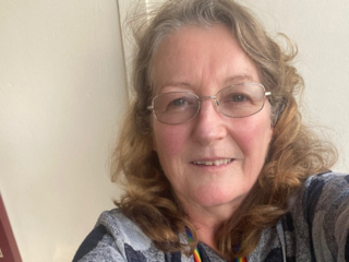 Photograph of Martina Cusack wearing a rainbow lanyard