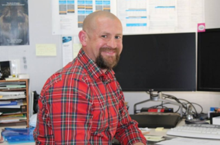 Photograph of GMW Water Storage Asset Planning Manager, Sam Green sitting at his desk at Tatura head office