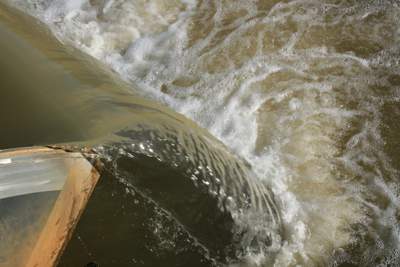 Channel water flowing through a flume gate.