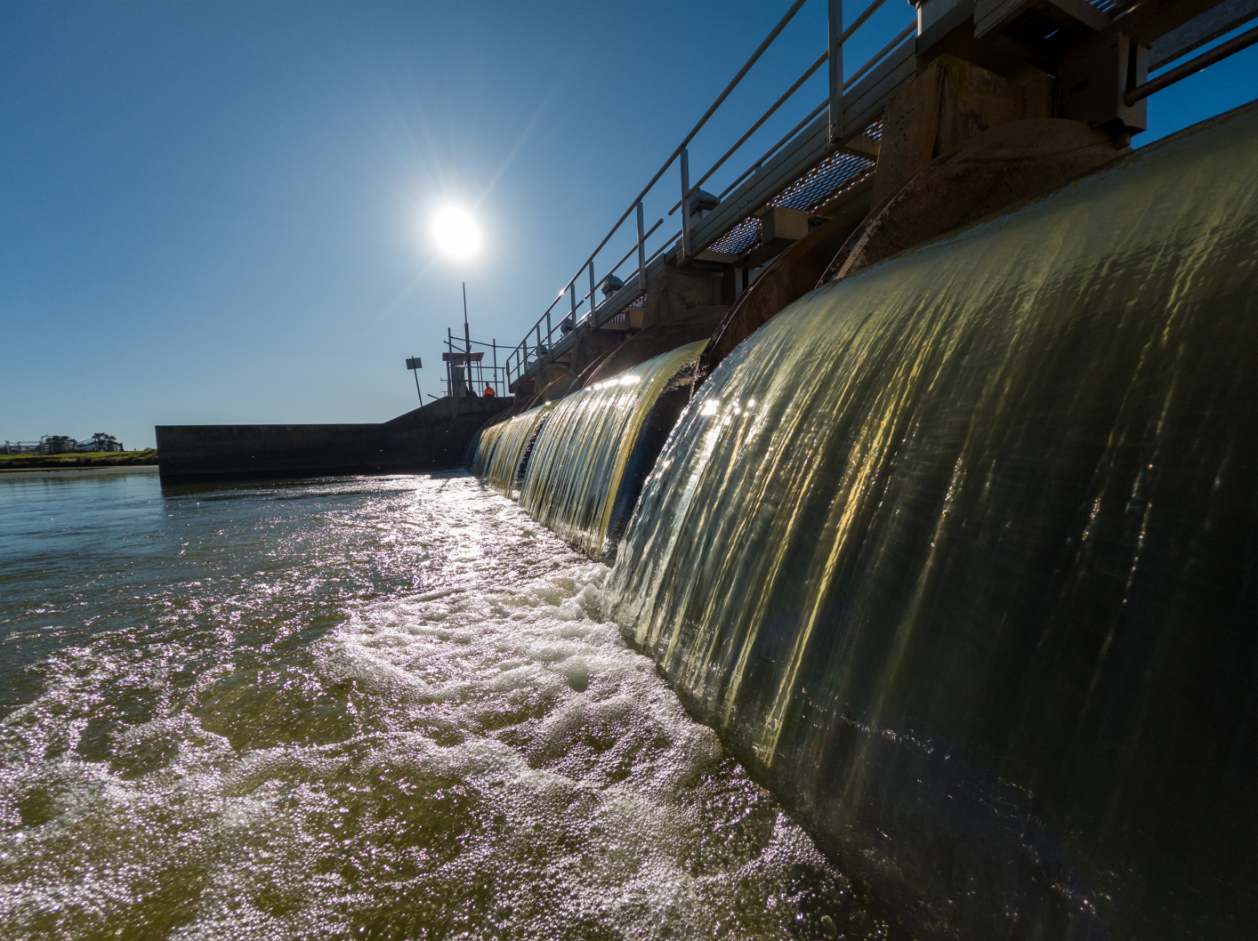 A photo of water flowing through a flume gate.